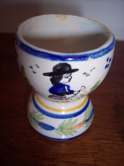 Appraisal: A Quimper egg cup decorated a gentleman in a landscape