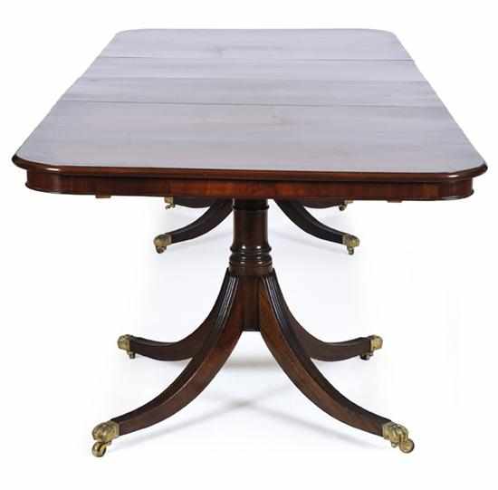 Appraisal: A REGENCY STYLE MAHOGANY EXTENSION DINING TABLE The rounded rectangular