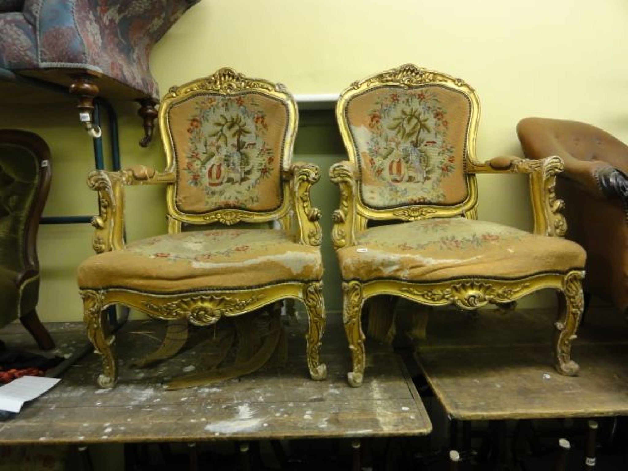 Appraisal: A pair of substantial gilt framed open armchairs with scrolling