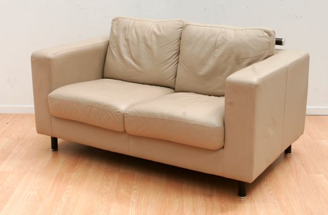 Appraisal: A beige leather upholstered two seater sofa