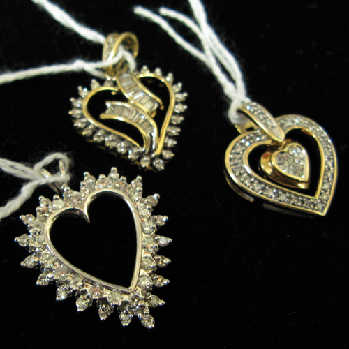 Appraisal: THREE DIAMOND AND GOLD OPEN HEART PENDANTS The lot includes