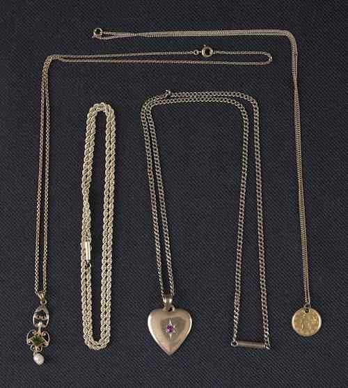 Appraisal: Four K yellow gold chains with a heart pendant containing