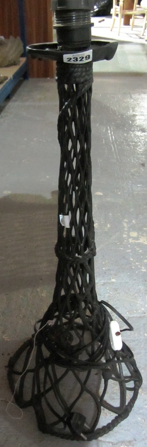 Appraisal: A wrought iron lamp base with black painted open wire