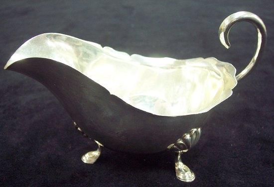 Appraisal: A sauce boat with scroll handle and legs with stepped