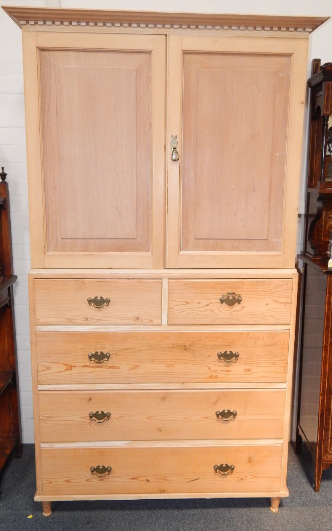 Appraisal: A stripped pine linen press the dentil moulded cornice above