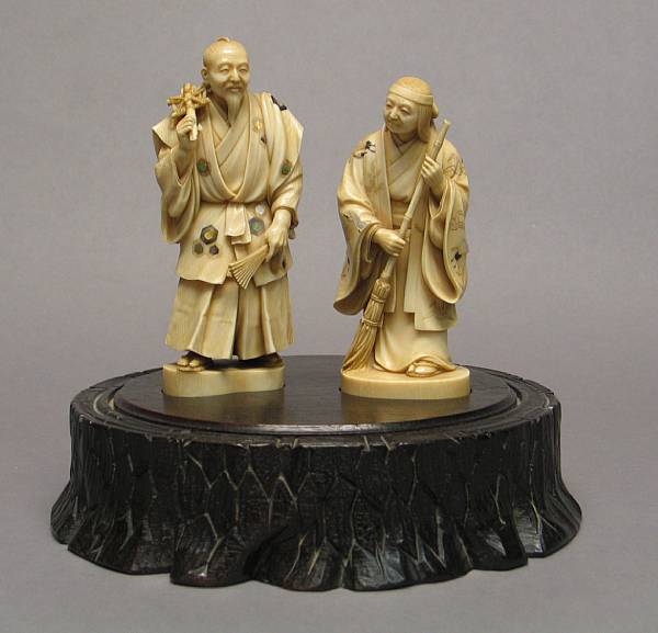 Appraisal: A pair of tinted ivory figures with mother-of-pearl inlay th