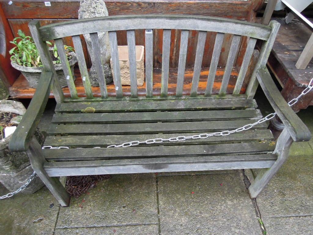 Appraisal: A weathered hardwood bench with slatted seat and back beneath