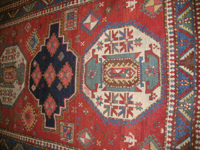 Appraisal: FINE KAZAK AREA RUG The abrashed red field of geometric