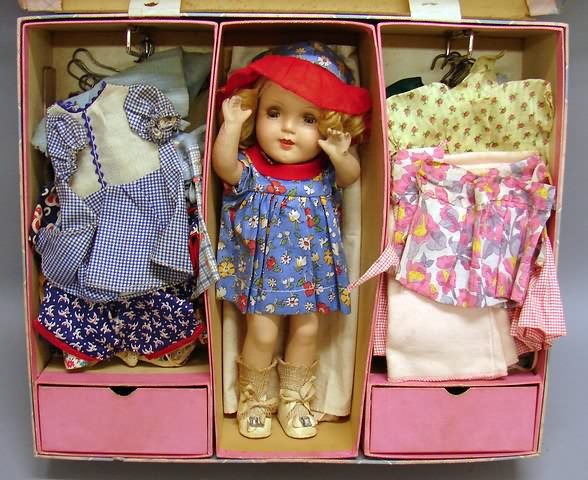 Appraisal: Lot Unmarked child doll with suitcase and wardrobe Blue tin