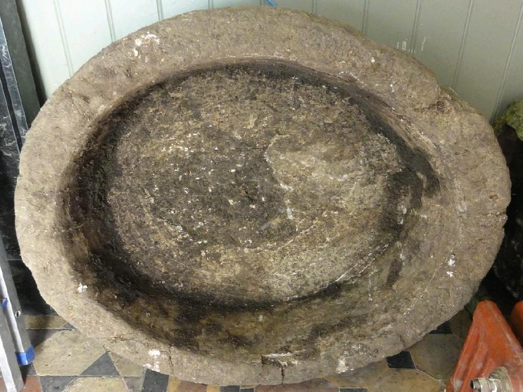 Appraisal: A weathered natural stone garden trough of circular form thick