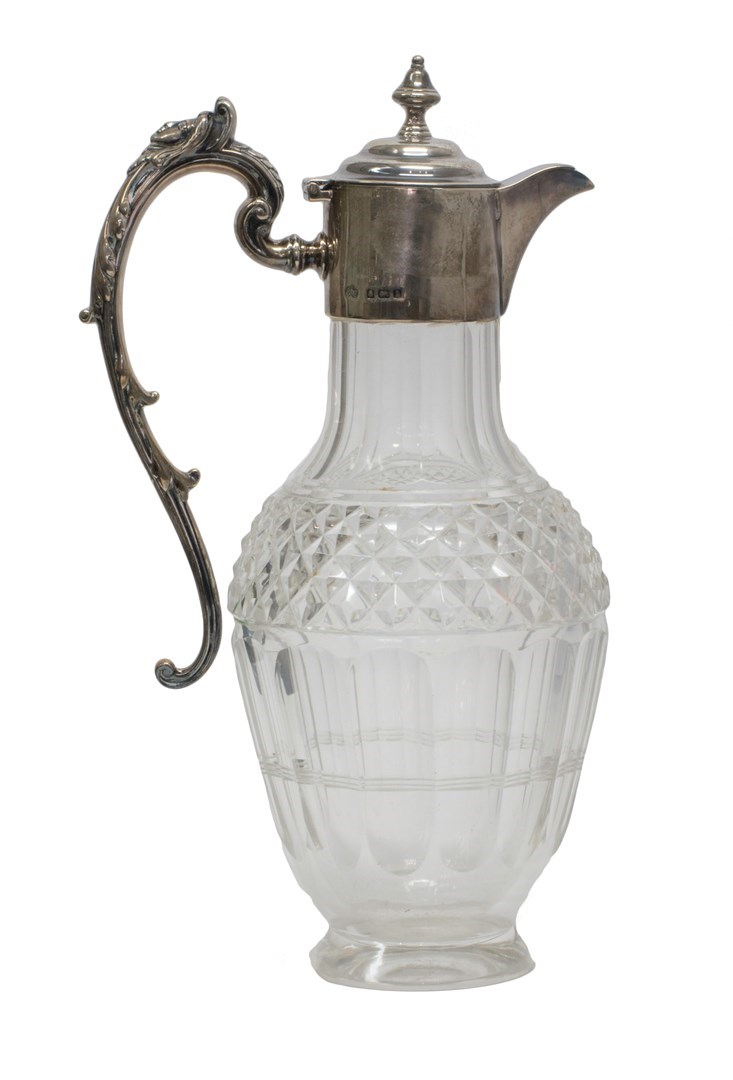 Appraisal: A silver mounted faceted glass claret jug the scrolling handle