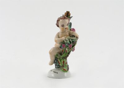 Appraisal: A Girl-in-a-Swing scent bottle modelled as Cupid resting his bow