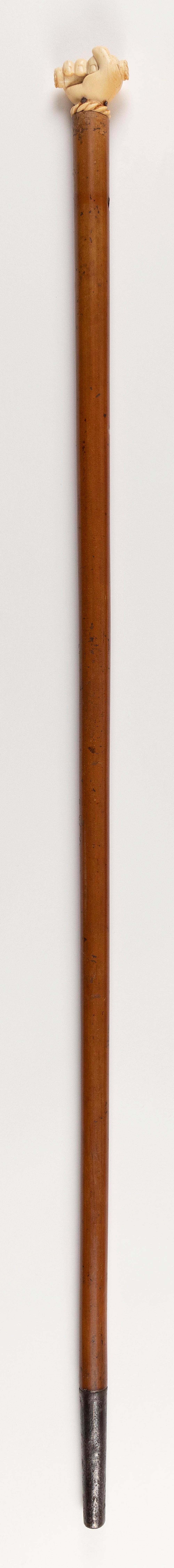 Appraisal: CANE WITH WHALE IVORY CLENCHED FIST HANDLE TH CENTURY LENGTH