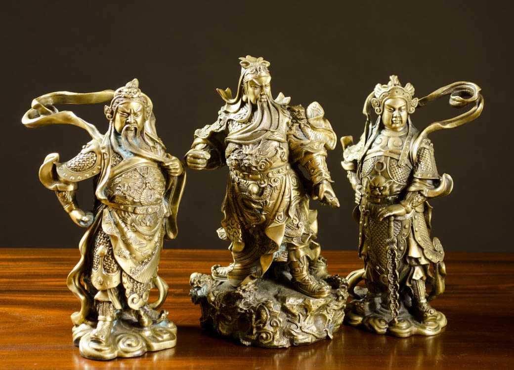 Appraisal: THREE BRONZE CHINESE WARRIORS each standing and dressed in armor