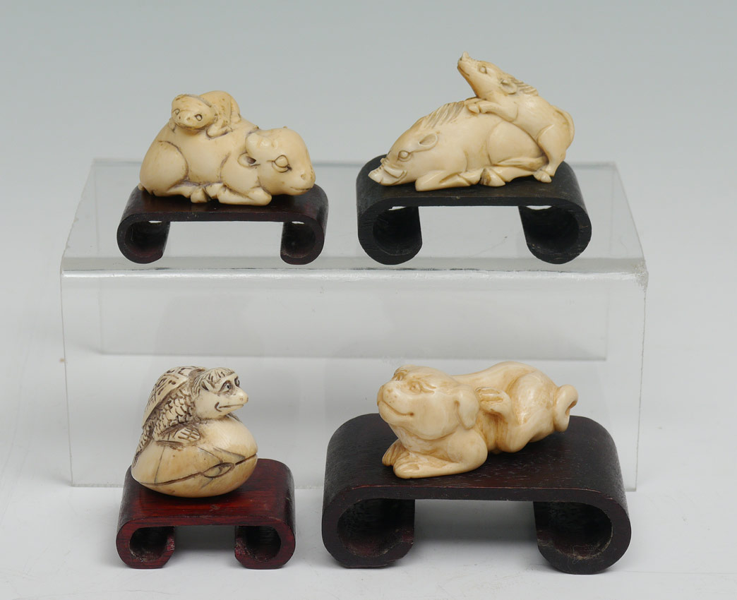 Appraisal: CARVED IVORY NETSUKE pieces total each with a wood stand