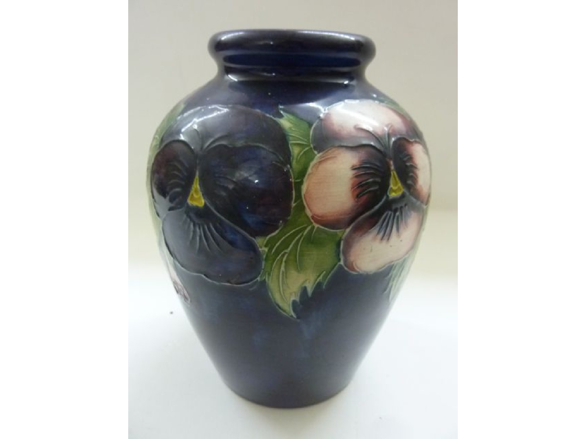 Appraisal: A Moorcroft oviform vase with trailing pansy panels upon a