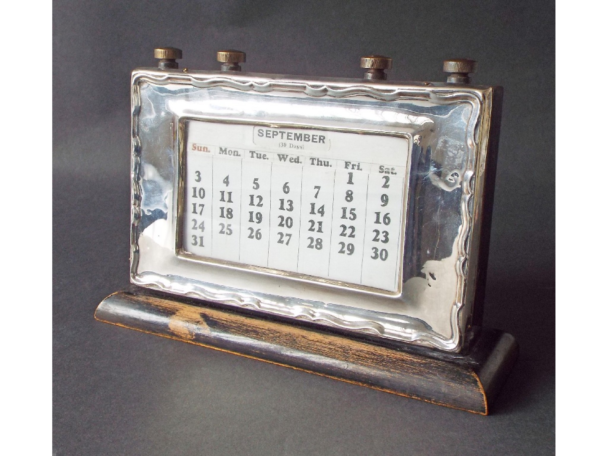 Appraisal: s silver framed perpetual calendar on wooden plinth base maker