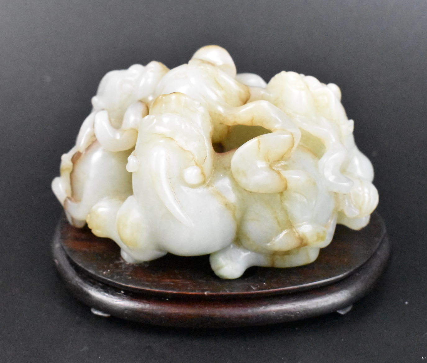 Appraisal: A Chinese jade carving of three foo lions cahsing a