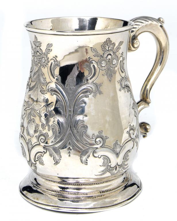 Appraisal: A GEORGE II MUG with leaf capped scrolling handle on