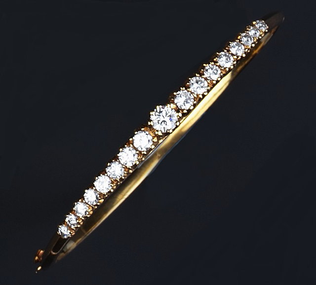 Appraisal: A diamond set bangle of hinged oval form claw set