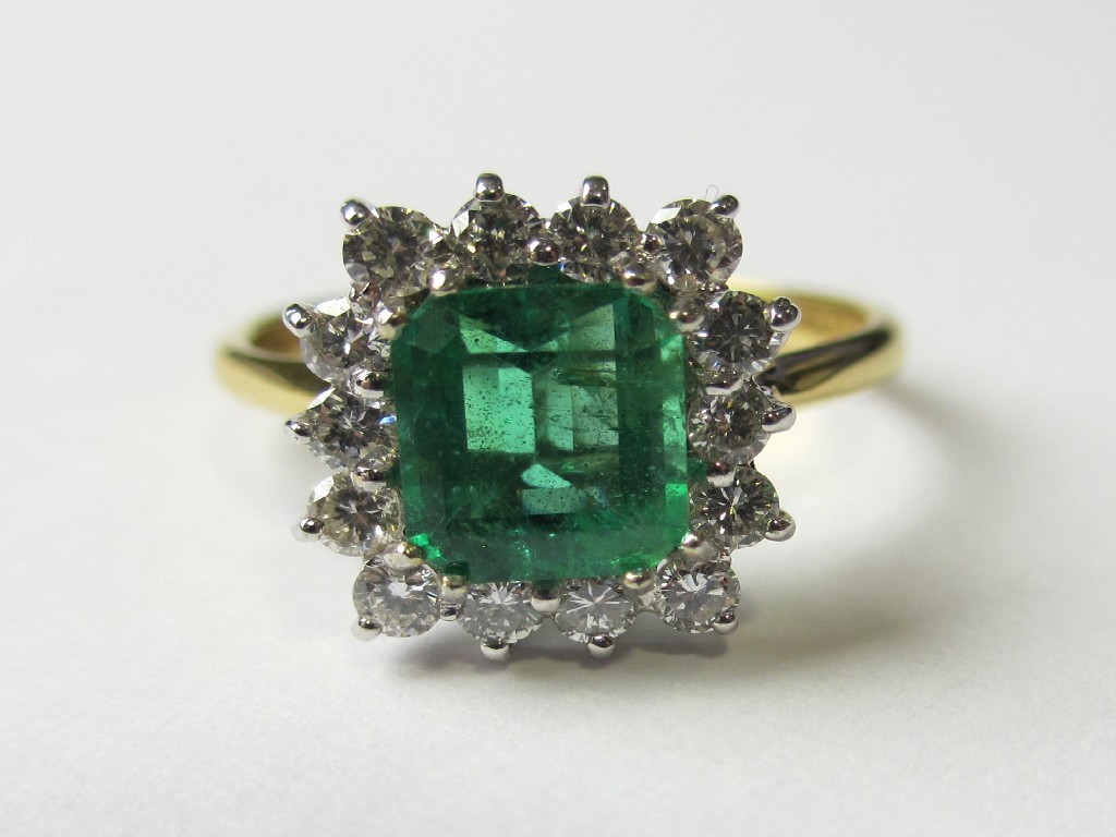 Appraisal: An eighteen carat bi colour gold emerald and diamond cluster