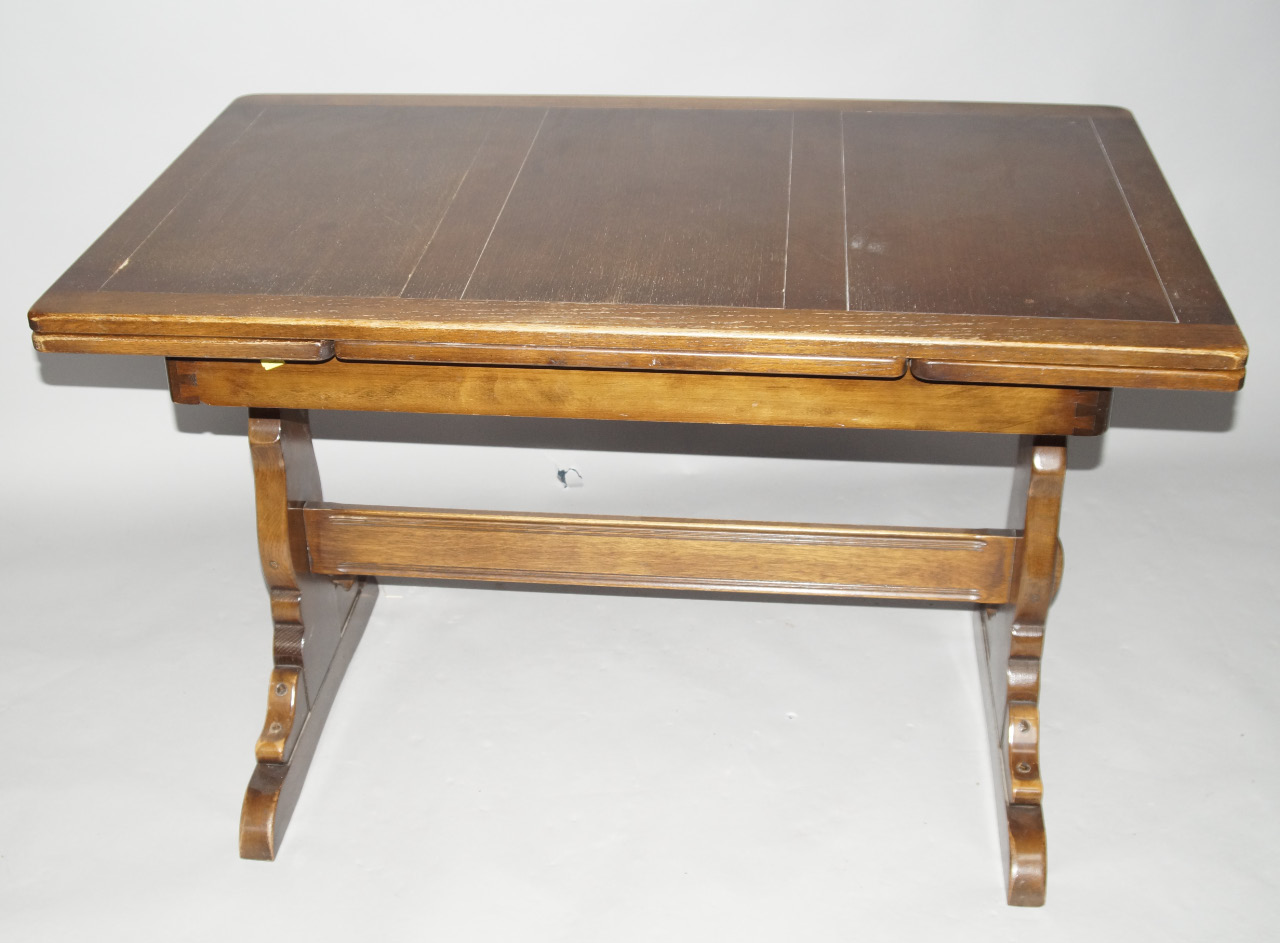 Appraisal: An Ercol oak extending refectory style dining table on shaped