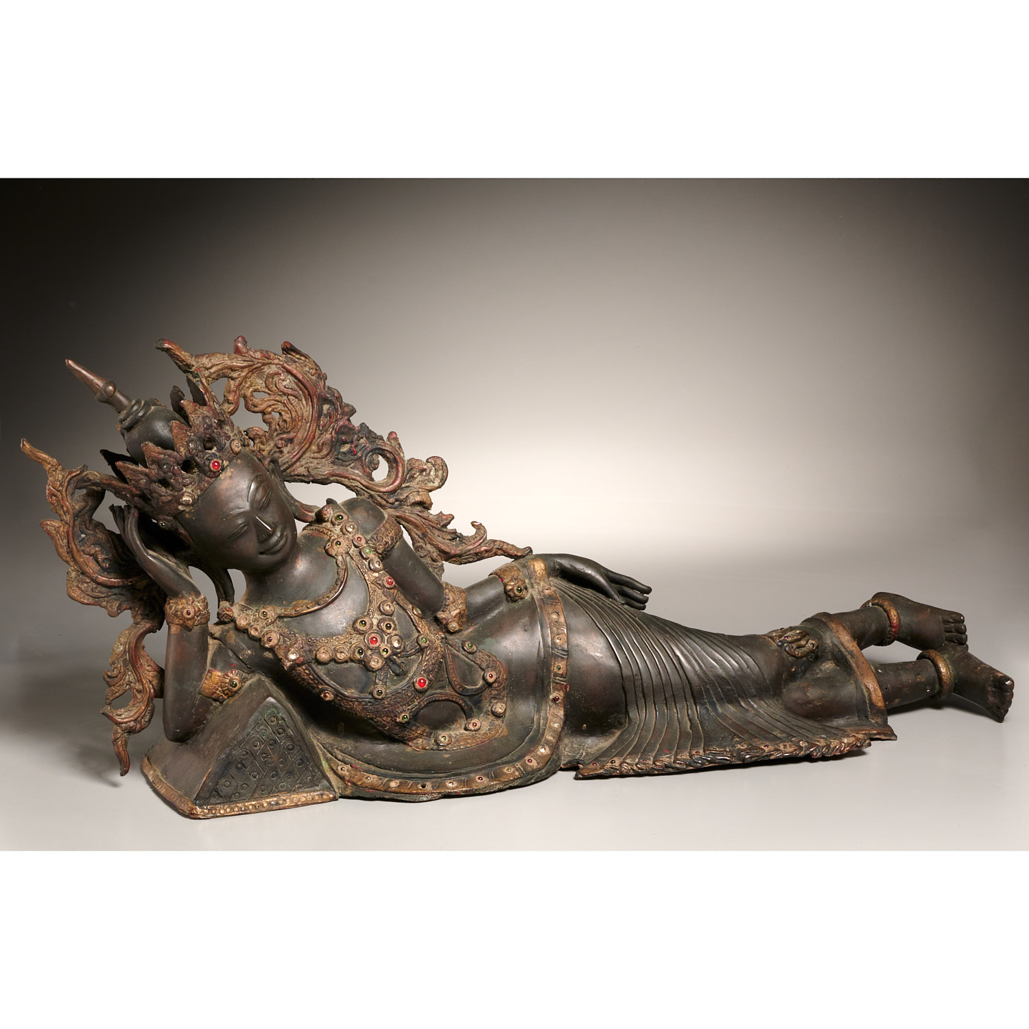 Appraisal: BURMESE BRONZE RECUMBENT BUDDHA th c dark patinated and gilt