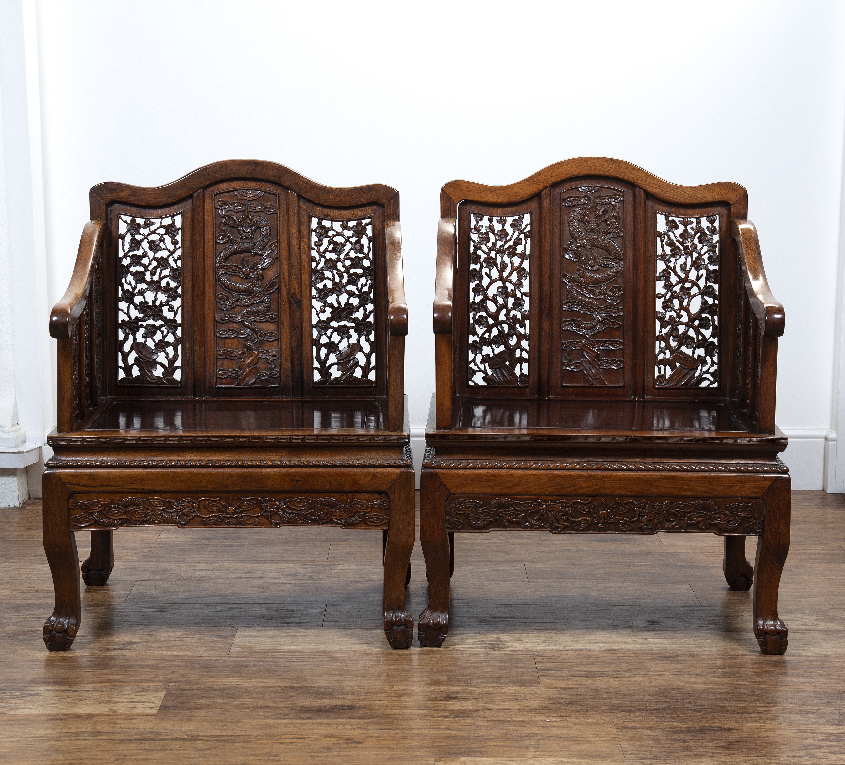 Appraisal: Pair of Ming-style carved hardwood armchairsChinese th Century the central