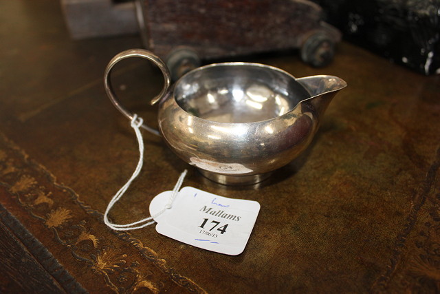 Appraisal: A SMALL HAMMERED SILVER CREAM JUG of squat form with