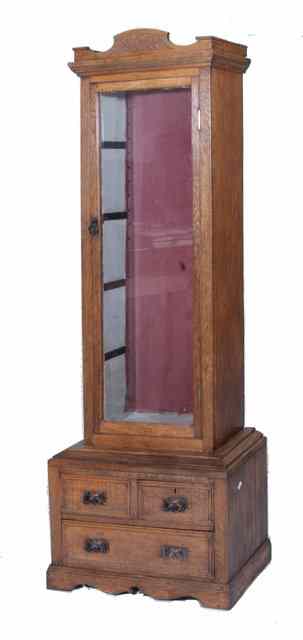 Appraisal: AN OAK DISPLAY CABINET the upper section with single glazed