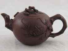 Appraisal: A Chinese brown globular Yixing style teapot with naturalistic handle