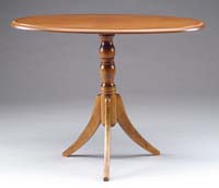 Appraisal: MODERN OVAL WALNUT STAND Molded edge top supported by a