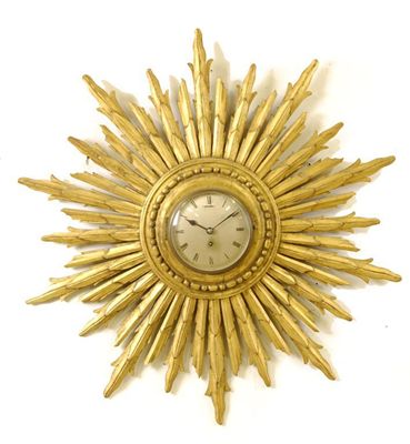 Appraisal: A carved giltwood sunburst wall clock with a single barrel