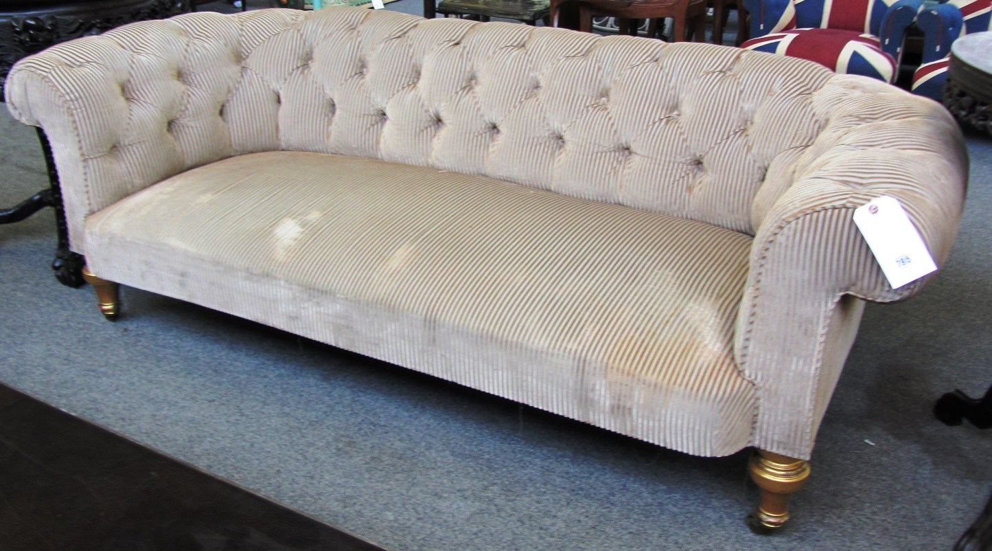 Appraisal: A pair of Victorian buttonback Chesterfield sofas on gold painted