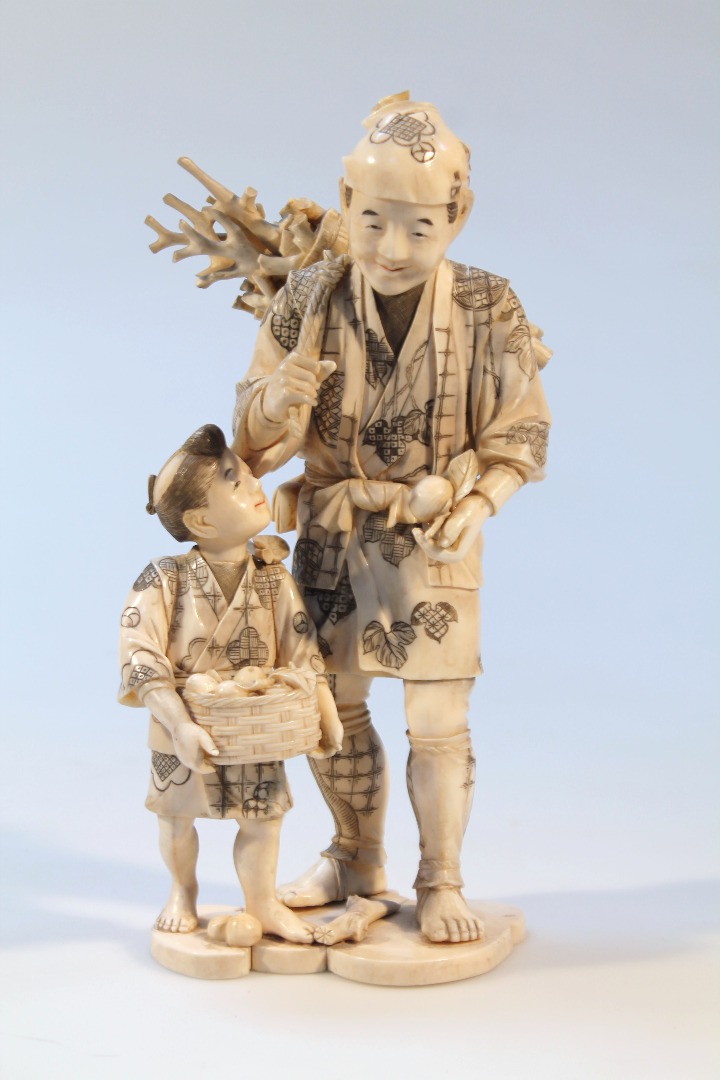 Appraisal: A thC Japanese ivory figure group of a gentleman and