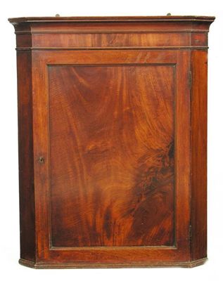 Appraisal: An early th century mahogany hanging corner cupboard with a