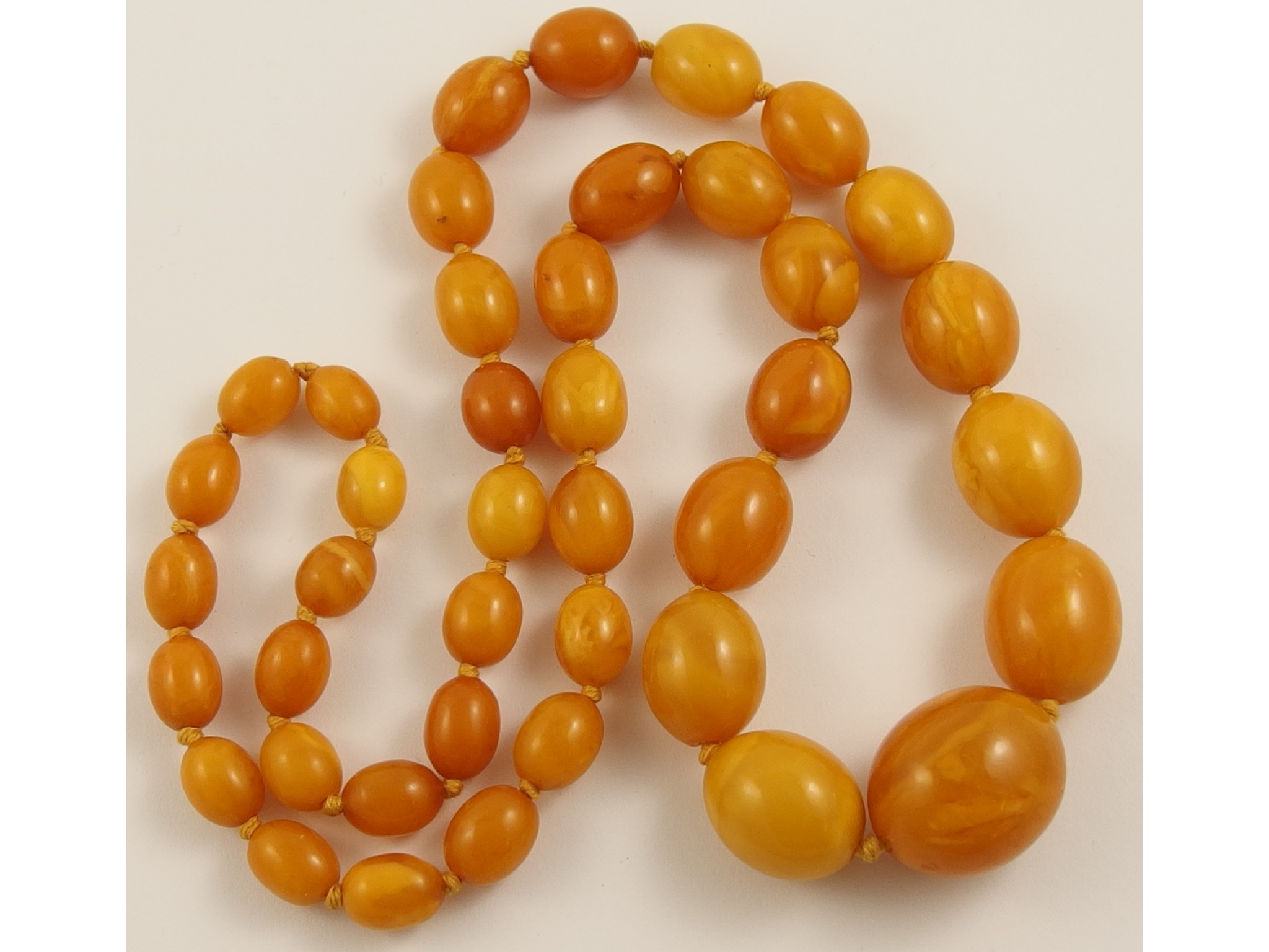 Appraisal: A string of butterscotch amber coloured beadsapprox length cm beads