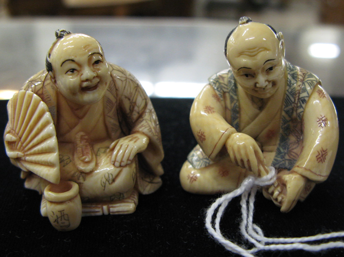 Appraisal: TWO JAPANESE CARVED IVORY NETSUKE each depicts a man in