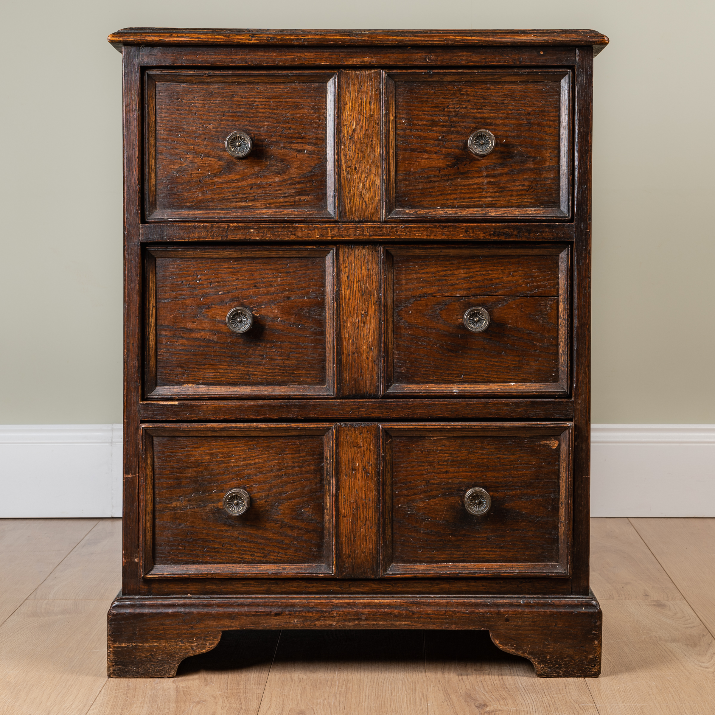 Appraisal: A small oak chest of three drawers with panelled sides