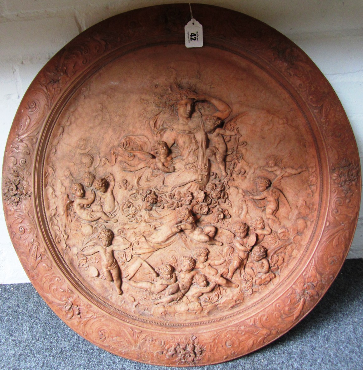 Appraisal: A terracotta relief roundel th century depicting a maiden surrounded