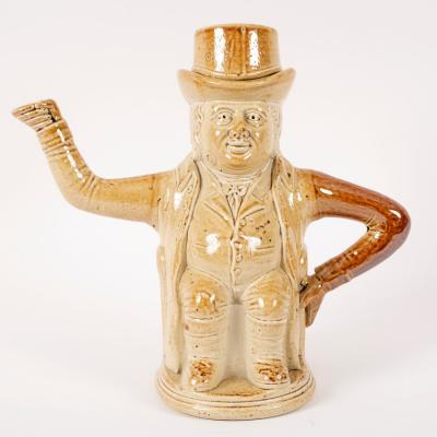 Appraisal: A Brampton stoneware honey coloured teapot modelled as a man