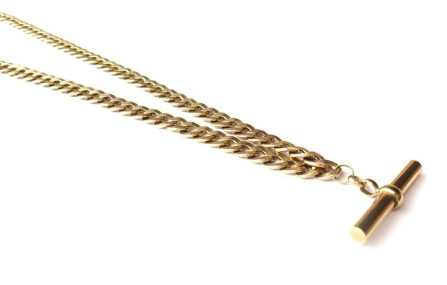 Appraisal: A gold faceted curb link chain with a T bar