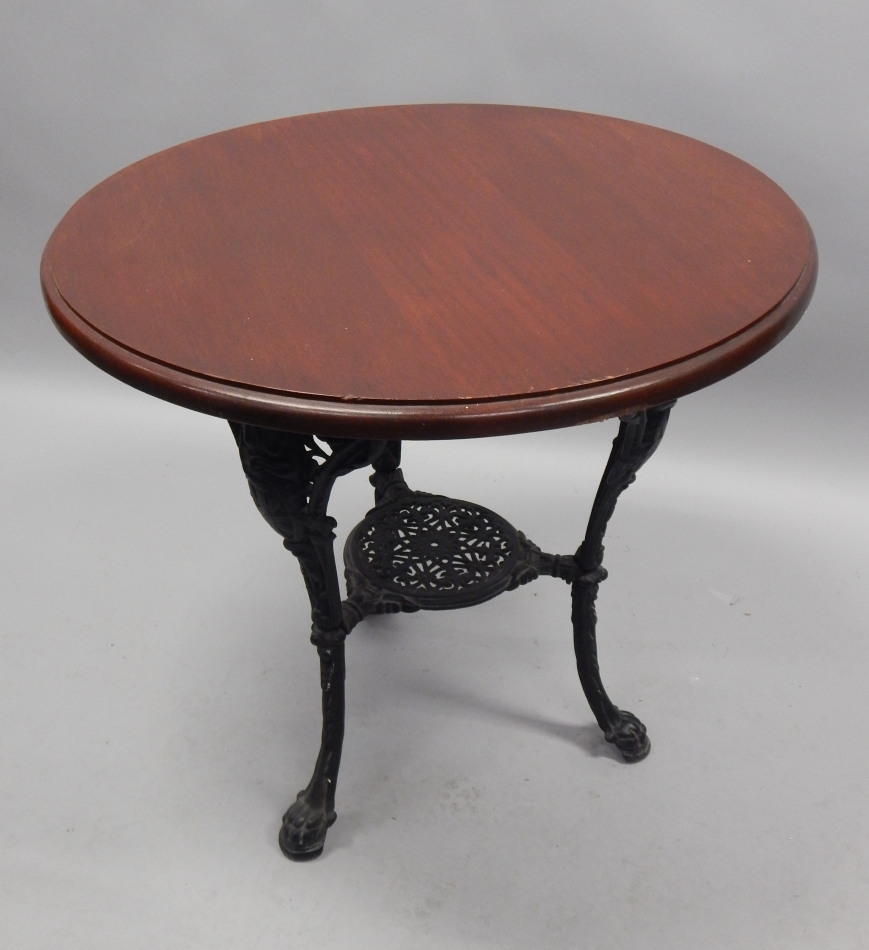 Appraisal: A cast iron Britannia pub table with mahogany top