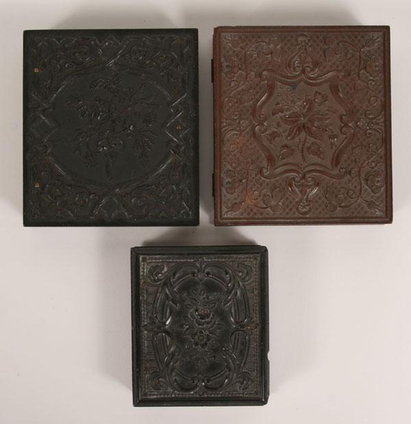 Appraisal: Three tintype portraits gutta percha cases with embossed floral designs