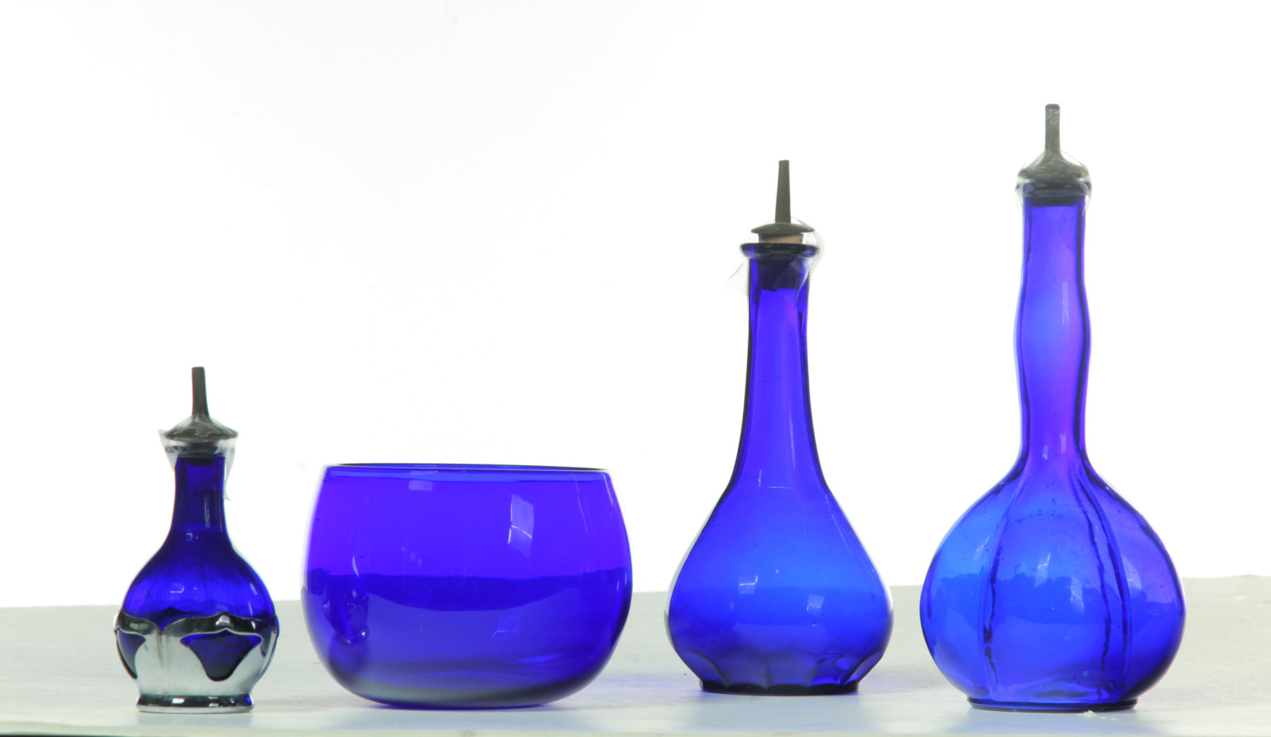 Appraisal: FOUR PIECES OF COBALT GLASS American c Two barber bottles