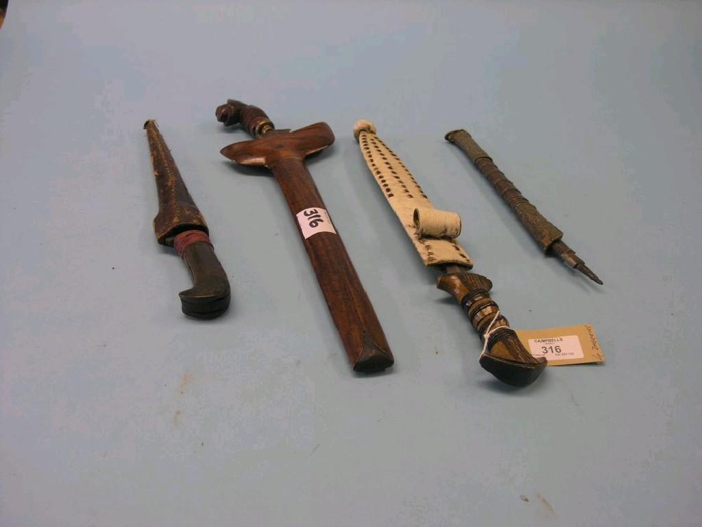 Appraisal: Four tribal daggers each contained within sheath one dagger handle