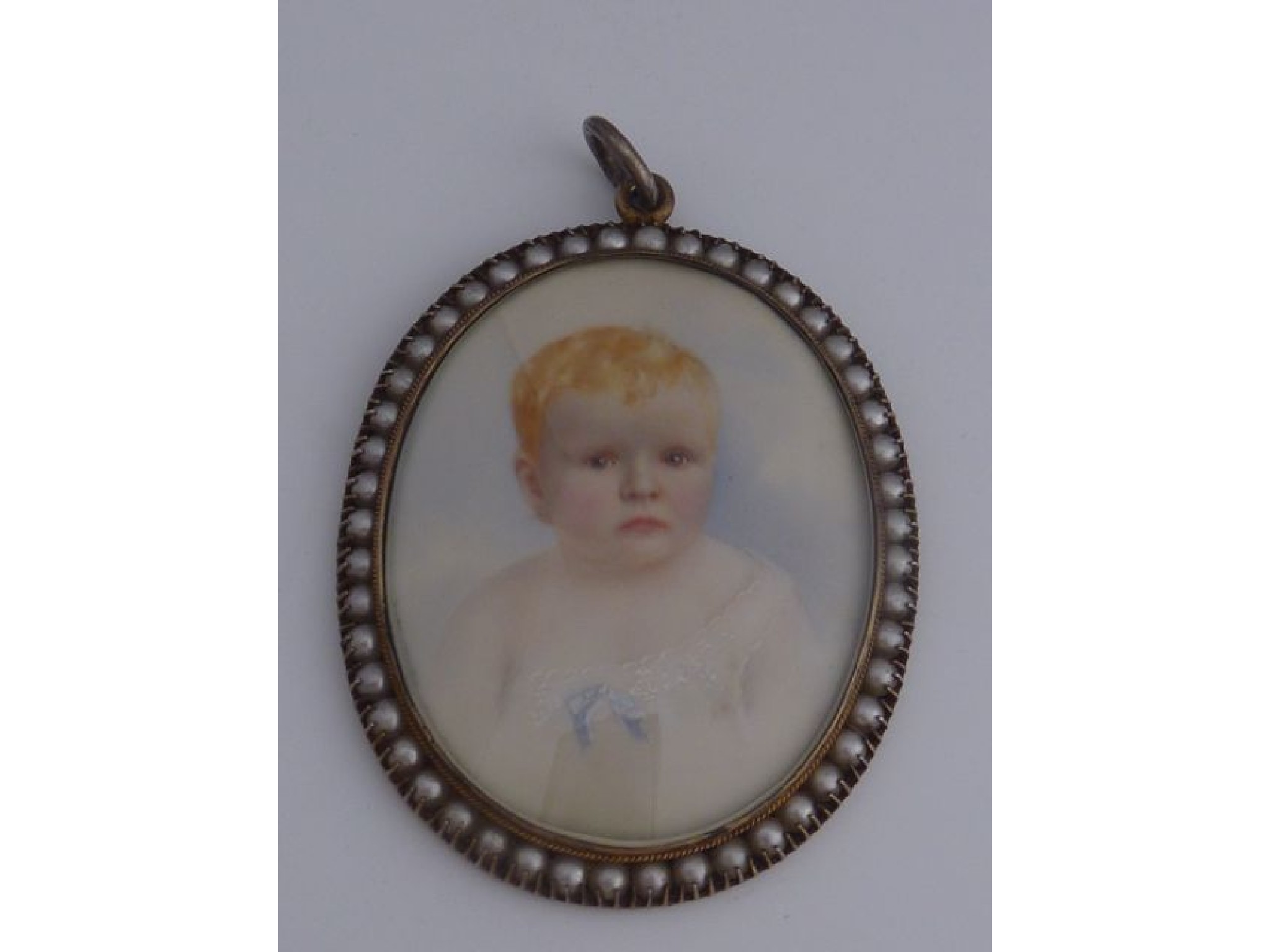 Appraisal: An oval miniature painted portrait of a young child in