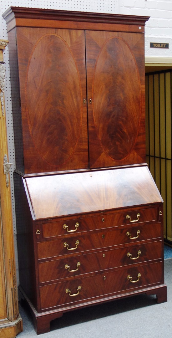 Appraisal: A George III mahogany bureau cabinet the pair of doors