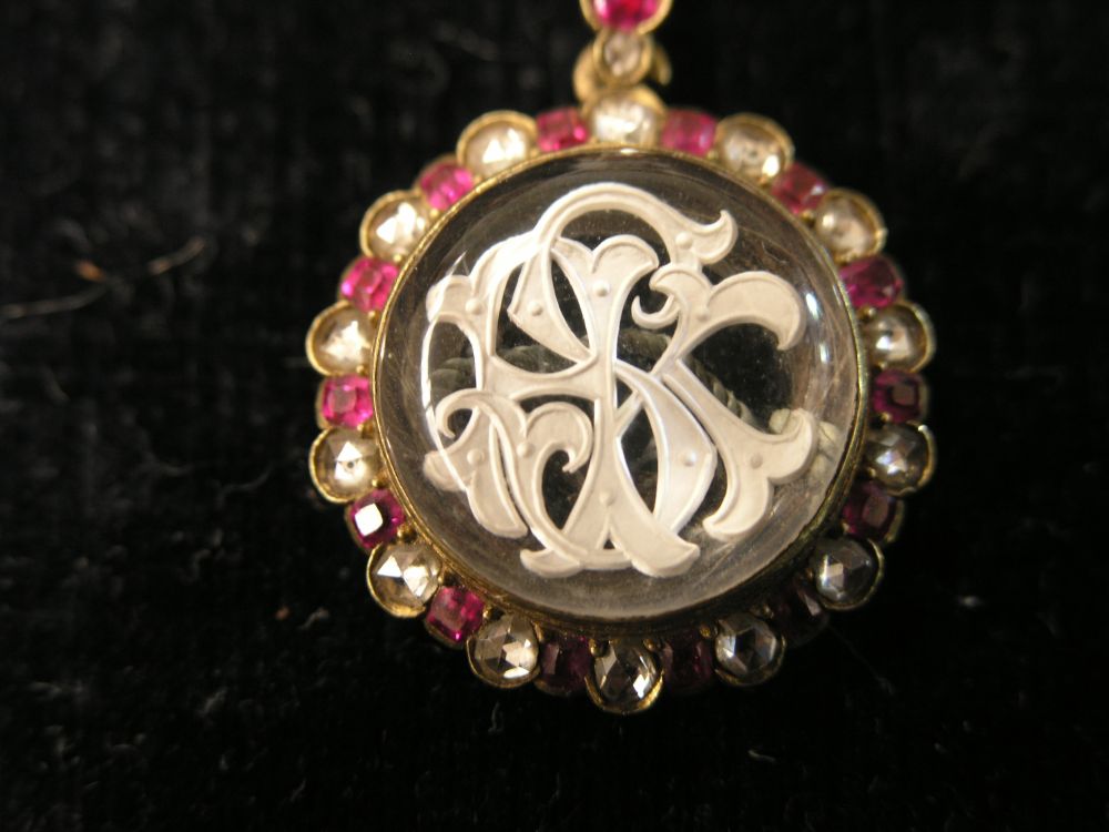 Appraisal: A pendant on chain with monogram surrounded by clear and