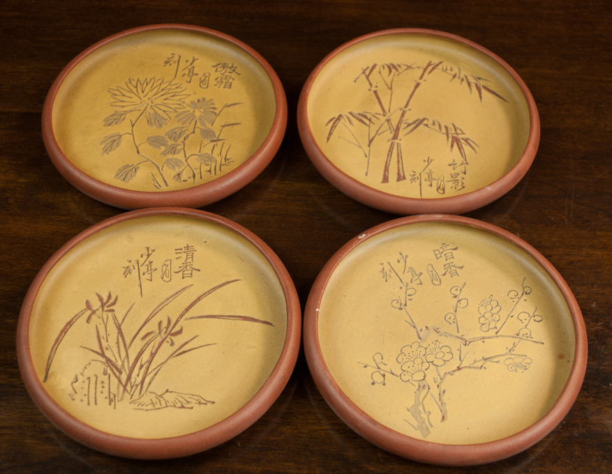 Appraisal: FOUR CHINESE ZISHA POTTERY PLATES with varied patterns of cherry